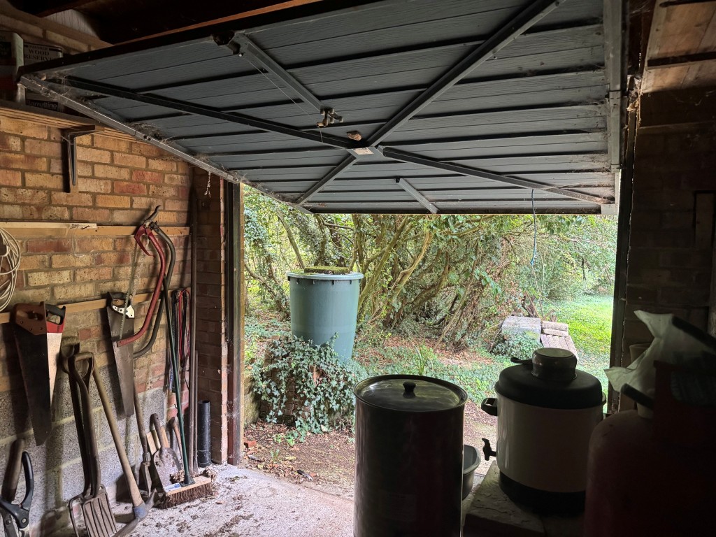 Lot: 47 - APPROXIMATELY HALF AN ACRE OF LAND WITH VACANT POSSESSION - Internal shot of up and over door of garage